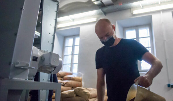 Hobbybrauer Christoph Wolfrum beim Malzschroten in der Brauwerkstatt der Maisel-Brauerei