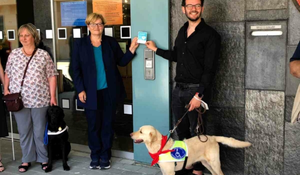 Freude beim Anbringen eines Stickers am Neuen Rathaus: Martina Hellriegel vom Bayerischen Blinden- und Sehbehindertenbund e.V. mit Hund Raven, MdB Anette Kramme, Zweiter Bürgermeister Andreas Zippel und Hund Matou. Bild: Jürgen Lenkeit