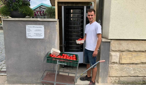 Florian Schmidt, Leiter der Gärtnerei Schmidt in Bayreuth, füllt den neuen Automaten mit frischen Tomaten. Bild: Michael Kind